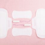 PMS, Period products arranged symmetrically on pink background