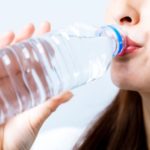hydration concept. a young woman drinking a bottle of water.