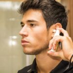 Young Man Spraying Ear Spray into Ears