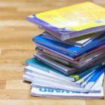 Stack of Textbooks and Black Backpack on Wooden Floor. Education, School Holidays, Back to School Concept. Copy Space.