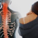 Close up of a brunette woman massaging her neck in a bedroom, composition