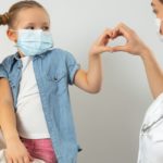 Caucasian mother and her kid wearing medical masks in clinic