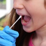 doctor performs a medical swab to the girl who seems to have no