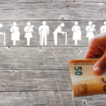 Family and Weak social categories welfare concept on wooden background with Euros in hand