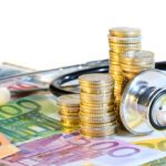 Bank notes and coins with a stethoscope around it