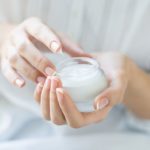 Beautiful woman hands applying moisturizer