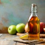 Apple vinegar. Bottle of apple organic vinegar or cider on wooden background. Healthy organic food. With copy space