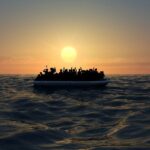 Refugees on a big rubber boat in the middle of the sea that require help