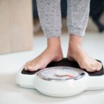 Close Up Of Woman Standing On Bathroom Scales At Home