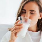 Young woman drinking milk from cup