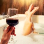 Relaxing in bathtub with glass of red wine