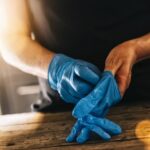 bartender or employee wearing a medical Latex gloves at work to prevent Coronavirus corona virus covid 19 infection.