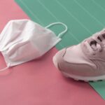 lady sport sneaker shoe with white health mask for covid 19 protection on pastel pink blue background