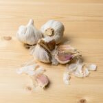 Heads and cloves of garlic isolated on wooden background