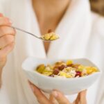 Closeup on woman in bathrobe eating healthy breakfast