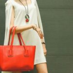 Fashionable beautiful red handbag on the arm of the girl