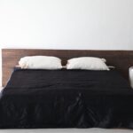 Interior white bedroom and bed with black sheets