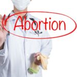 Doctor using red pen draw circle on abortion