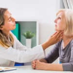 Doctor examines patient’s throat